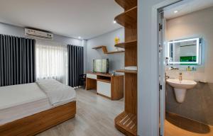 sypialnia z łóżkiem, umywalką i lustrem w obiekcie Coco Homestay w Duong Dong