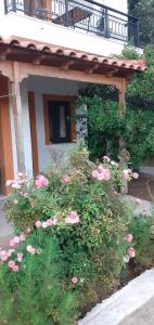 un ramo de flores rosas delante de un edificio en Daphne Studios, en Marathokampos