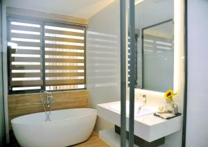 Khách Sạn LUCIEN HOTEL Quy Nhơn في كوي نون: حمام مع حوض أبيض ومغسلة