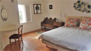 a bedroom with a bed and a desk and a chair at La Cachette village in Roussillon