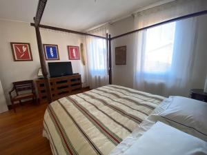 Ca' Mancio في فابريانو: غرفة نوم بسرير ونافذة وتلفزيون