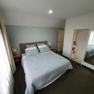 a bedroom with a large bed with white sheets and pillows at Midtown Tui Villa - Taupō Central Holiday Unit in Taupo +15 photos