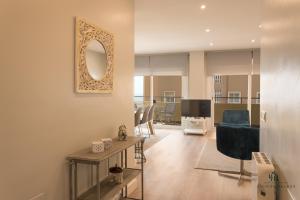 ein Wohnzimmer mit einem blauen Sofa und einem Spiegel in der Unterkunft Living4Malaga Arenal Superior Beach in Málaga