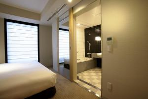 a hotel room with a bed and a mirror at KOKO HOTEL Premier Kanazawa Korinbo in Kanazawa