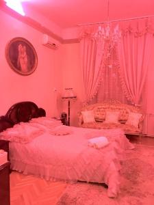 セゲドにあるÁdám Apartmanházのピンクのベッドルーム(天蓋付きの大型ベッド1台付)