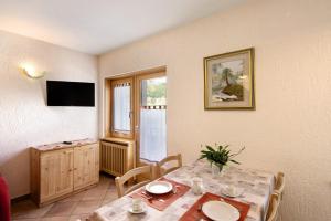 uma sala de jantar com uma mesa e uma televisão em Residence Attila Panorama em Livigno