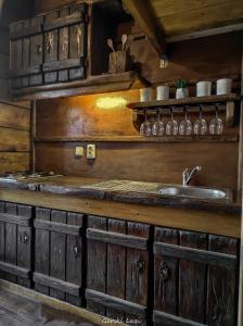 a kitchen with wooden cabinets and a sink at Tree House Gorski Lazi in Tršće +112 photos