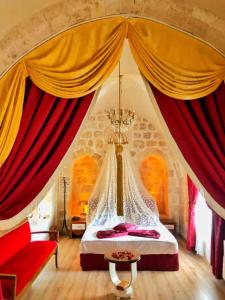 a bedroom with a bed with red curtains at Tuğhan Hotel in Mardin