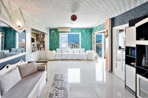 een woonkamer met witte meubels en groene muren bij Sea View Apartment - Studio in Chersonissos