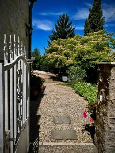 a gate to a house with a pathway with flowers at Domaine Des Deux Rivières in Meilhan-sur-Garonne