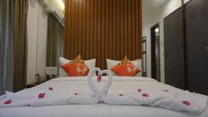 two swans made out of towels on a bed at 2BR Mumbai theme service apartment for staycation by FLORA STAYS in Mumbai