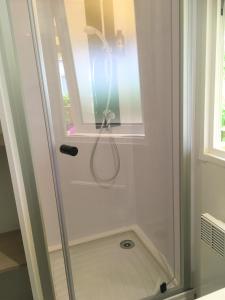 a shower with a glass door in a bathroom at Camping et Gîte La Garenne de moncourt baie somme in Rue