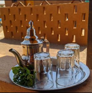einen Wasserkocher und zwei Gläser auf einem Teller in der Unterkunft Café restaurante shelter calm life 