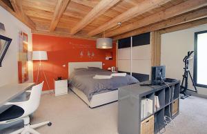 a bedroom with a bed and a desk with a computer at Chalet Sno Lodge in Les Deux Alpes