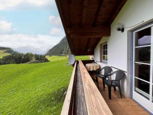 eine Veranda mit Stühlen, einem Tisch und einem grünen Feld in der Unterkunft Apartment Rieser - NIT130 by Interhome in Umhausen