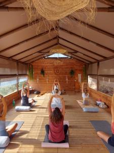 un grupo de personas haciendo yoga en una tienda en Salema Eco Camp - Sustainable Camping & Glamping en Salema