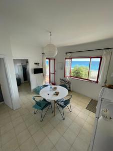 eine Küche und ein Esszimmer mit einem Tisch und Stühlen in der Unterkunft The Greek’ House in Bova Marina