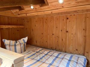 sypialnia z łóżkiem w drewnianej ścianie w obiekcie Apartment Rieser - NIT131 by Interhome w mieście Umhausen