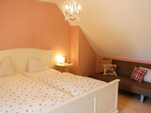 - une chambre avec un lit blanc et un canapé dans l'établissement Apartment Hofgasse - MOE110 by Interhome, à Mörbisch am See