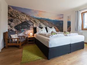 een slaapkamer met een groot bed en een schilderij aan de muur bij Holiday Home Pfisterer - BRG150 by Interhome in Taxenbach