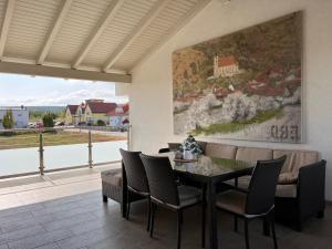 a dining room with a table and chairs and a painting at Apartment Fuchs-2 by Interhome in Donnerskirchen