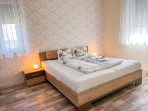 a bedroom with a bed with white sheets and pillows at Apartment Fuchs - DON161 by Interhome in Donnerskirchen