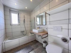 a white bathroom with a sink and a toilet at Apartment Fuchs-2 by Interhome in Donnerskirchen +25 photos