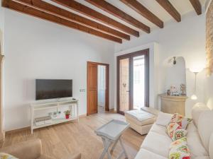 een woonkamer met een witte bank en een tv bij Holiday Home Cordella - SNY101 by Interhome in Santanyi