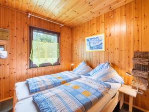 ein Schlafzimmer mit einem Bett in einer Holzhütte in der Unterkunft Apartment Erica-2 by Interhome in Überlingen
