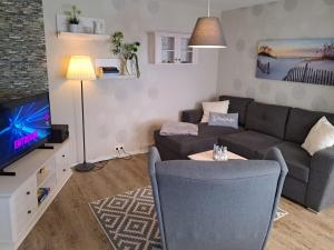 sala de estar con sofá y TV en Holiday Home Karli by Interhome en Loissin