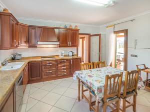cocina con mesa y armarios de madera en Holiday Home Peña Rubia - MUR146 by Interhome, en Cala Murada
