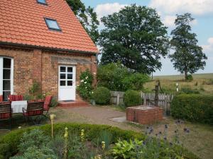 a brick house with a table and chairs in a garden at Holiday Home Kranich by Interhome in Troja