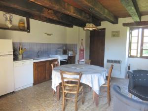 Una cocina con una mesa y sillas en una cocina. en Holiday Home Le Petit Gîte by Interhome, en Jayac 9 fotos más