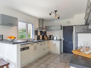 Una cocina grande con gabinetes blancos y una ventana. en Holiday Home Ker Simor Ty Mer by Interhome, en Kerlouan