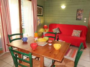 a living room with a table and a red couch at Chalet Le Chalet - A in Cancale