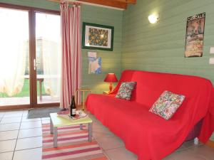 a living room with a red couch and a table at Chalet Le Chalet - A in Cancale