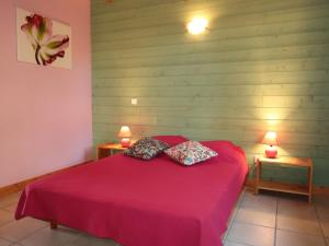 a bedroom with a red bed with two pillows at Chalet Le Chalet by Interhome in Cancale +16 photos