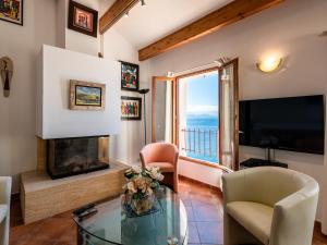 a living room with a fireplace and a television at Holiday Home Maison Balbi by Interhome in Canari