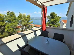 uma mesa e cadeiras numa varanda com vista para a água em Apartment Anđa-3 by Interhome em Trogir