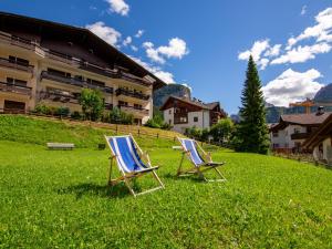 two lawn chairs sitting in the grass in front of a building at Apartment Cisles by Interhome in Selva di Val Gardena