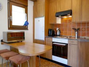 eine Küche mit einem Holztisch und einer Arbeitsplatte in der Unterkunft Apartment Gemmi by Interhome in Albinen
