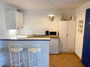 a kitchen with two stools at a blue counter top at Apartment Les terrasses de la Plage-1 by Interhome in Cap d'Agde