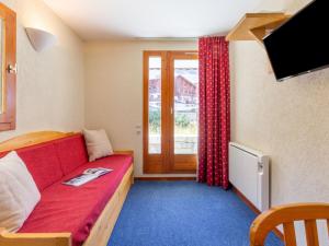 une chambre avec un canapé rouge et une fenêtre dans l'établissement Apartment Chalet Club-1 by Interhome, à Tignes