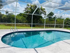 una gran piscina con cubierta blanca en Villa Hibiscus by Interhome, en Bonita Springs