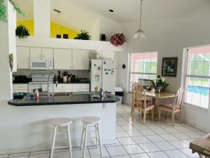 cocina con armarios blancos, mesa y sillas en Villa Hibiscus by Interhome, en Bonita Springs
