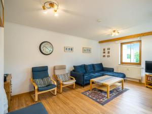 a living room with a couch and two chairs and a clock at Apartment Haus Kitzsteinhorn by Interhome in Zell am See +17 photos