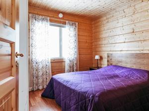 - une chambre avec un lit violet et une fenêtre dans l'établissement Holiday Home Aapeli iso by Interhome, à Inhantehtaat