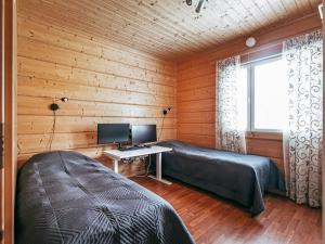 1 Schlafzimmer mit 2 Betten und einem Schreibtisch mit einem Computer in der Unterkunft Holiday Home Aapeli iso by Interhome in Inhantehtaat + 16 Fotos