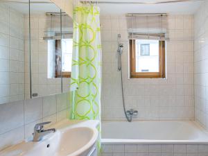 een badkamer met een bad, een wastafel en een douche bij Apartment Haus Kitzsteinhorn by Interhome in Zell am See