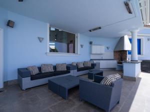 una sala de estar con paredes y sofás azules y una cocina. en Holiday Home Finca Edel by Interhome, en Cumbre del Sol